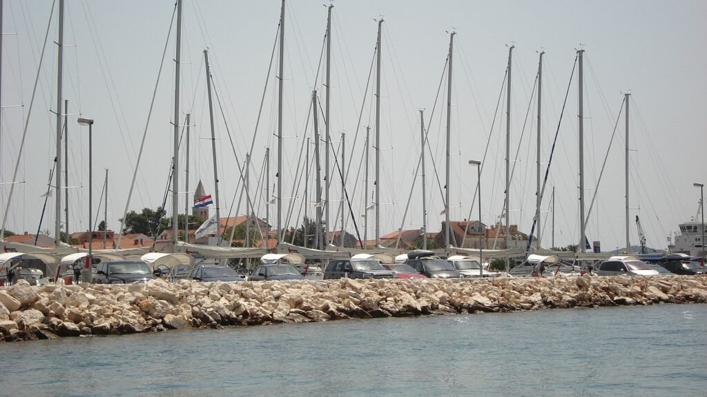 Masten zahlreicher Segelyachten in der Marina von Biograd na Moru, dahinter Altstadt mit Kirchturm