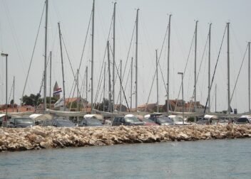 Masten zahlreicher Segelyachten in der Marina von Biograd na Moru, dahinter Altstadt mit Kirchturm